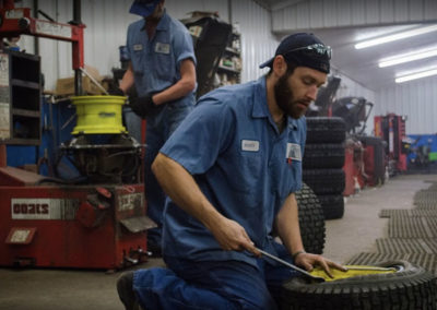 two men working on tires in a garage