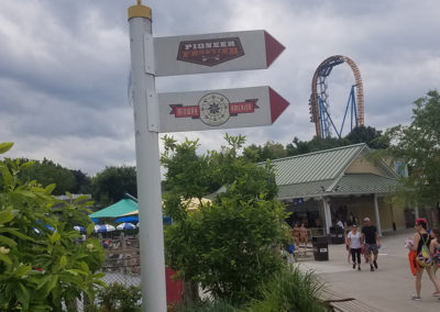 a sign pointing to several different locations in the park
