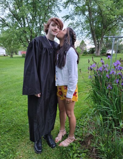 two girls in graduation gowns kissing each other