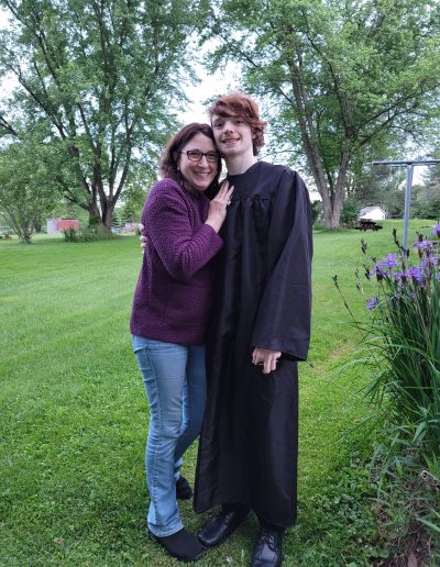 two people in graduation gowns standing next to each other
