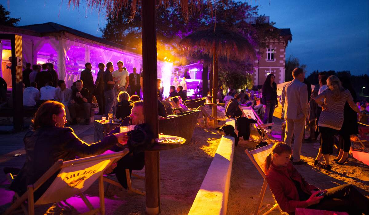 a group of people sitting around tables at night