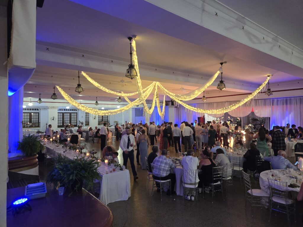 a group of people standing around a room filled with tables