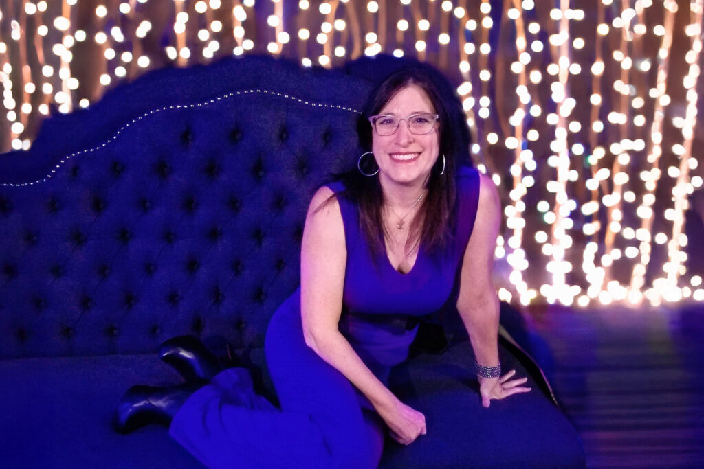 a woman in a blue dress sitting on a blue couch